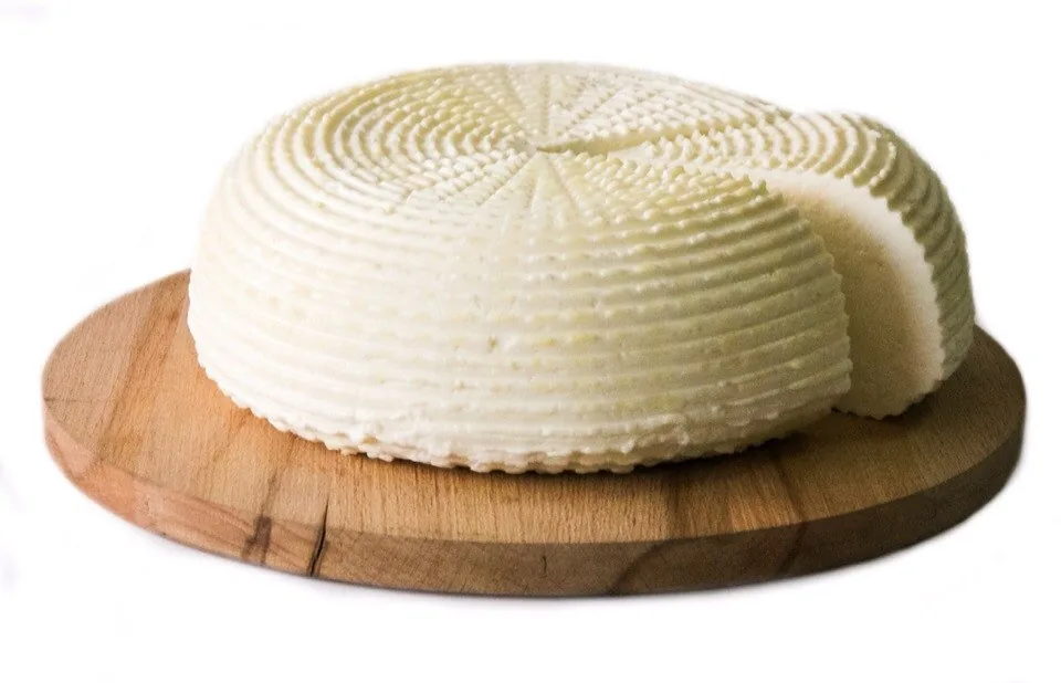 A round of Adyghe cheese with the woven basket pattern pressed into its sides