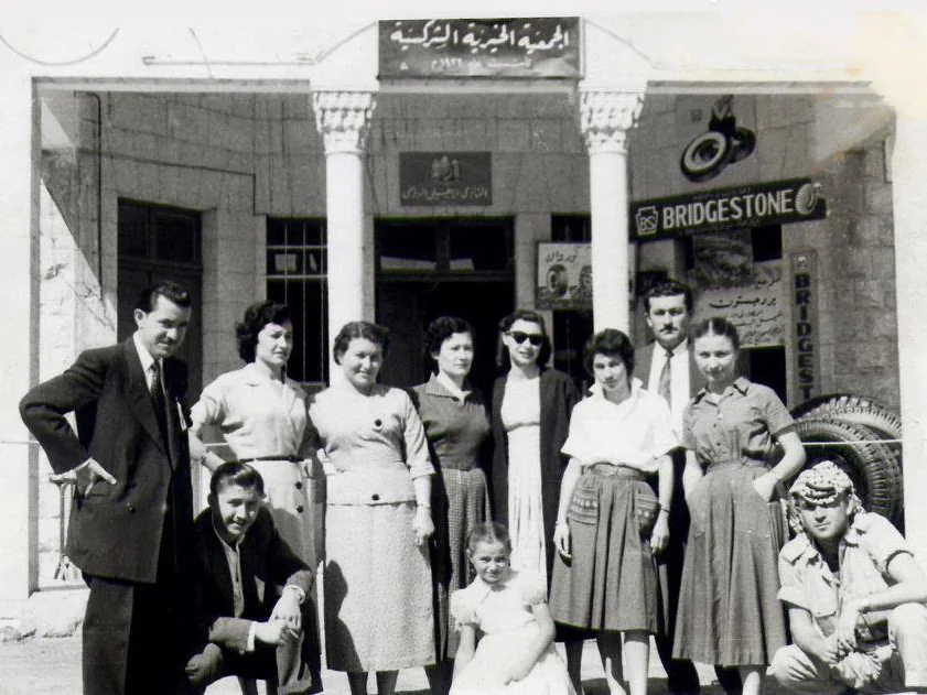 مجموعة من الرجال والنساء أمام مبنى الجمعية الخيرية الشركسية في عمّان، 1958