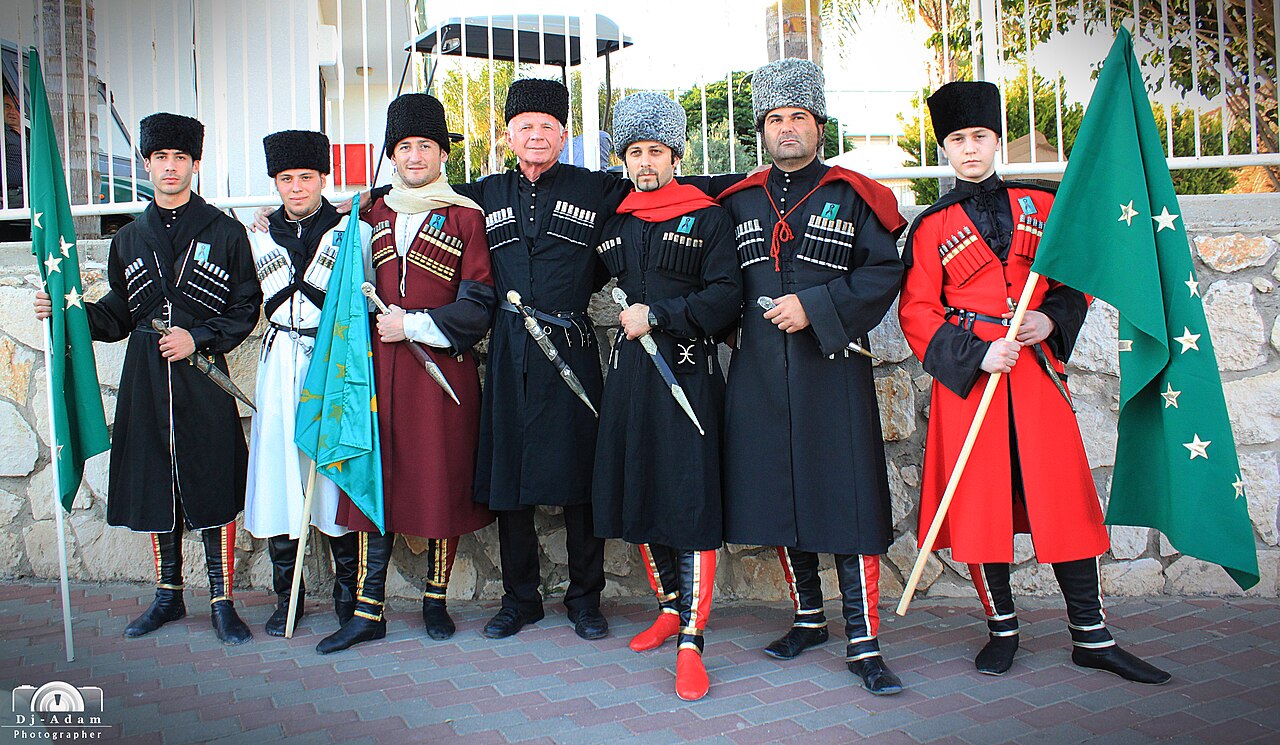 Circassian men in traditional cherkesska coats with gazyr cartridge holders at a cultural event