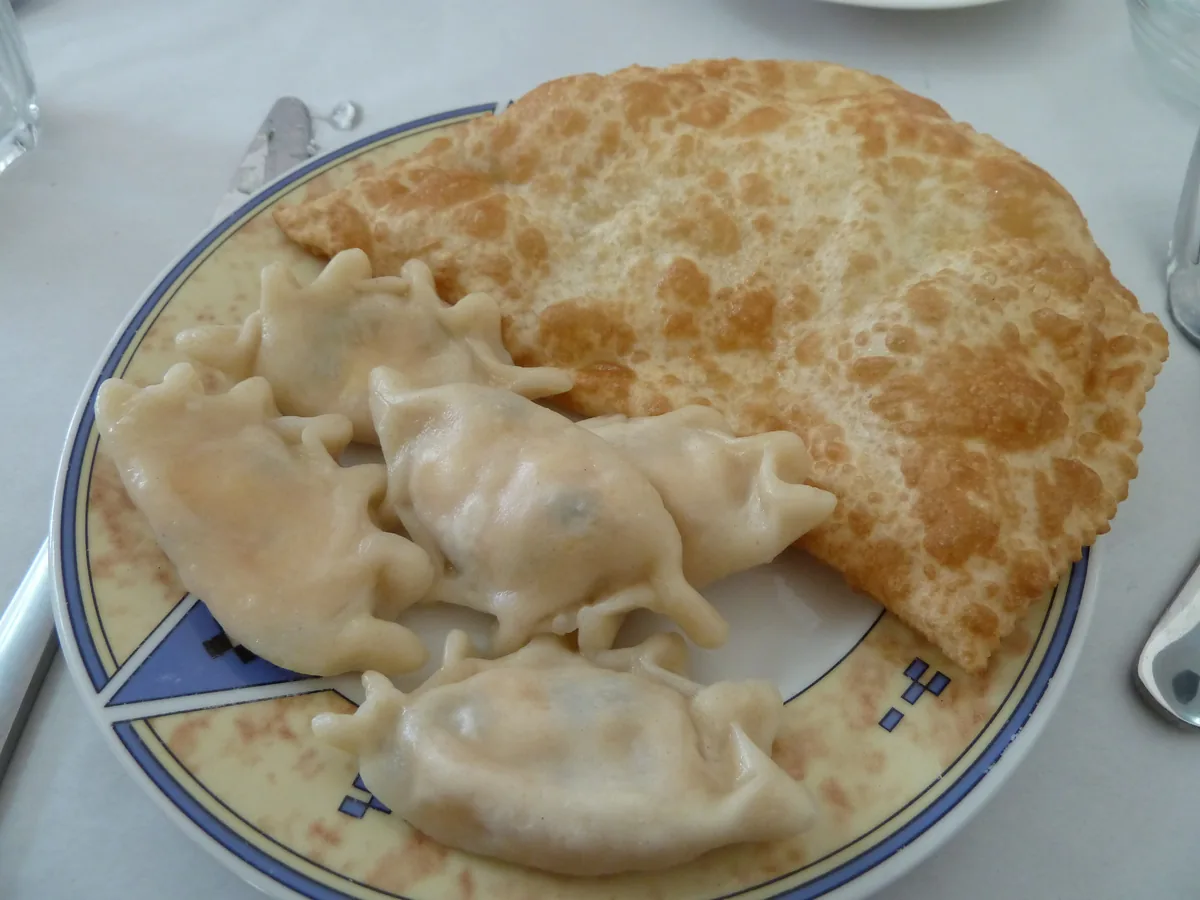 A plate with a fried haliva pie and boiled mataz dumplings